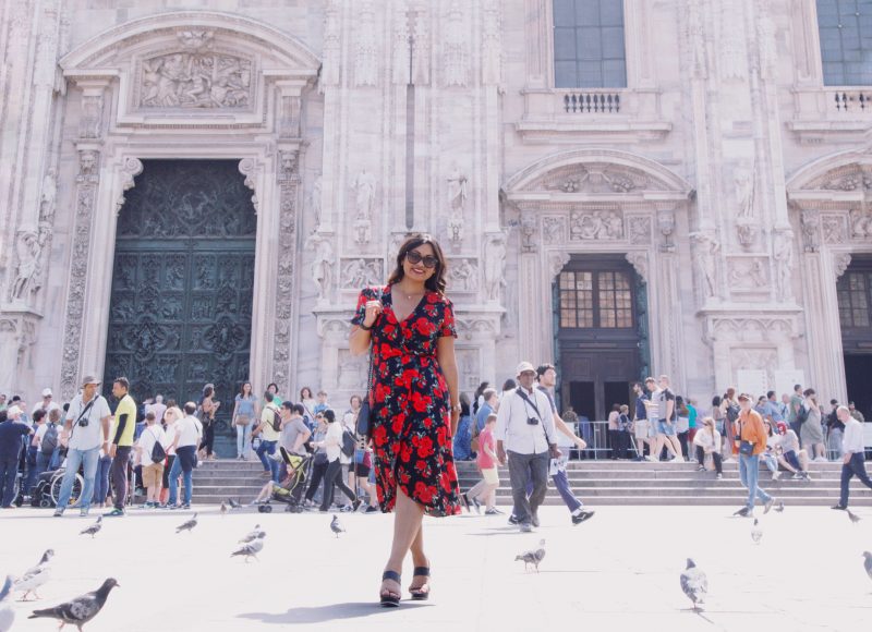 Fashion blogger outside of Duomo di Milano wearing a rose printed summer dress from Primark, black and brown wedges from Vince Camuto and a Rebecca Minkoff handbag.