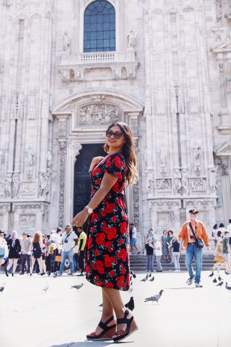 Fashion blogger outside of Duomo di Milano wearing a rose printed summer dress from Primark, black and brown wedges from Vince Camuto and a Rebecca Minkoff handbag.