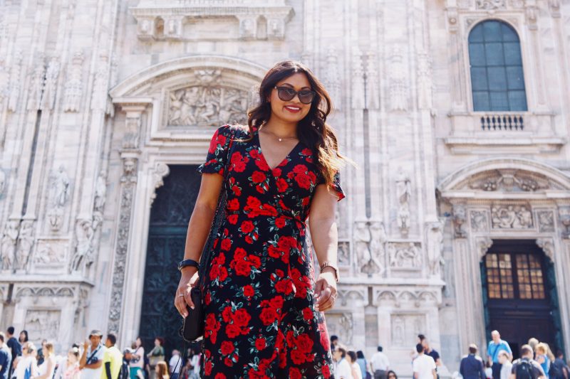 Fashion blogger outside of Duomo di Milano wearing a rose printed summer dress from Primark, black and brown wedges from Vince Camuto and a Rebecca Minkoff handbag.